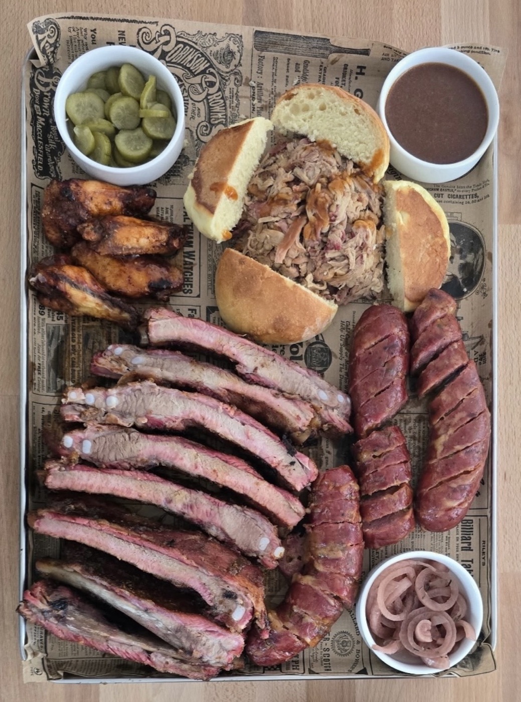 Plateau garni de ribs, saucisses, pulled pork et accompagnements