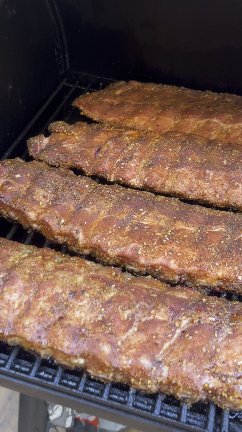Ribs de porc fumées, quatre travers sur la grille du fumoir
